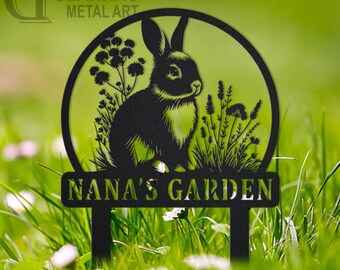 May include: Black metal garden sign featuring a rabbit silhouette within a circular frame, surrounded by floral details. The sign reads "NANA'S GARDEN" and is mounted on stakes for easy placement in a garden. The Gearwag Metal Art logo is in the upper left corner.