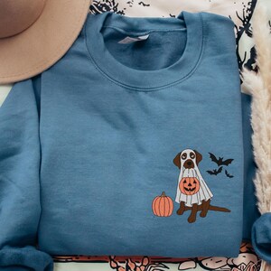 Embroidered Chocolate Lab in Ghost Costume With Pumpkin and Bats and Jack O Lantern Trick Or Treat Bag on Indigo Blue Unisex Gildan 18000 Sweatshirt