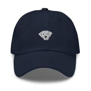 May include: A navy blue baseball cap with an embroidered white dog face.