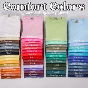 May include: A variety of t-shirt colors stacked in columns, with the text "Comfort Colors Heavyweight Unisex T-Shirt" at the top. The colors include white, ivory, espresso, gray, granite, pepper, black, banana, butter, citrus, mustard, peachy, burnt orange, melon, terracotta, yam, blossom, neon pink, peony, crunchberry, watermelon, heliconia, paprika, red, crimson, brick, orchid, violet, berry, vineyard, grape, celedon, island reef, sandstone, khaki, bay, seafoam, island green, grass, light green, hemp, moss, emerald, blue spruce, chambray, hydrangea, chalky mint, lagoon blue, sapphire, flo blue, periwinkle, washed denim, ice blue, blue jean, denim, and true navy.