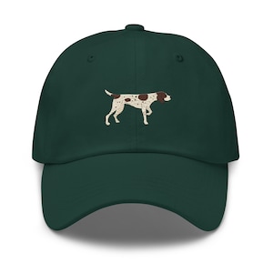 May include: A dark green baseball cap with an embroidered brown and white dog illustration.
