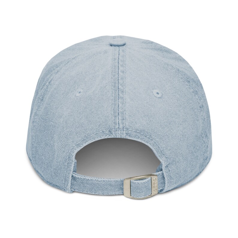 May include: A light blue denim baseball cap with a silver buckle closure.