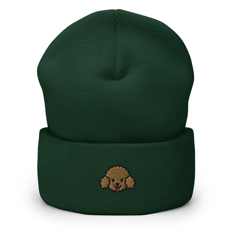 Puede incluir: Un gorro de lana verde oscuro con un rostro de caniche bordado en marr&oacute;n en la parte delantera.
