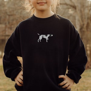 May include: Black sweatshirt with a white embroidered image of a black and white dog.
