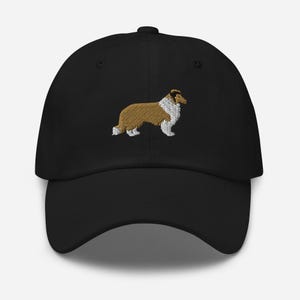 Puede incluir: Gorra de béisbol negra con un diseño bordado de un perro Collie. El perro está representado en tonos marrón, blanco y dorado. La gorra tiene una visera curva y un diseño clásico y estructurado. Un accesorio elegante para los amantes de los perros.