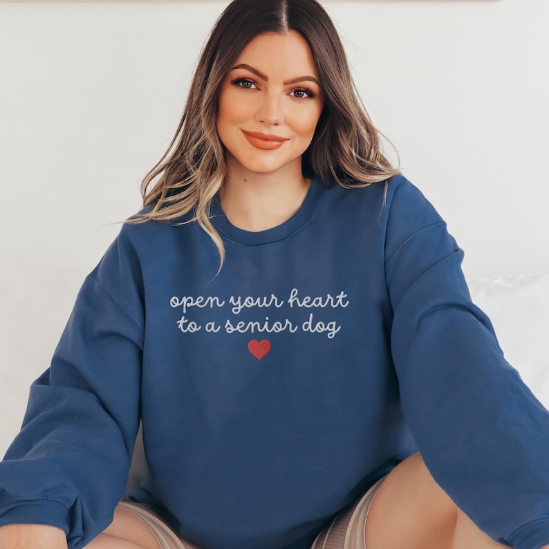 May include: A navy blue sweatshirt with the text "open your heart to a senior dog" in white lettering and a red heart.