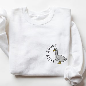 May include: White sweatshirt with a gray goose illustration and the text "Silly goose" in a circle around it.