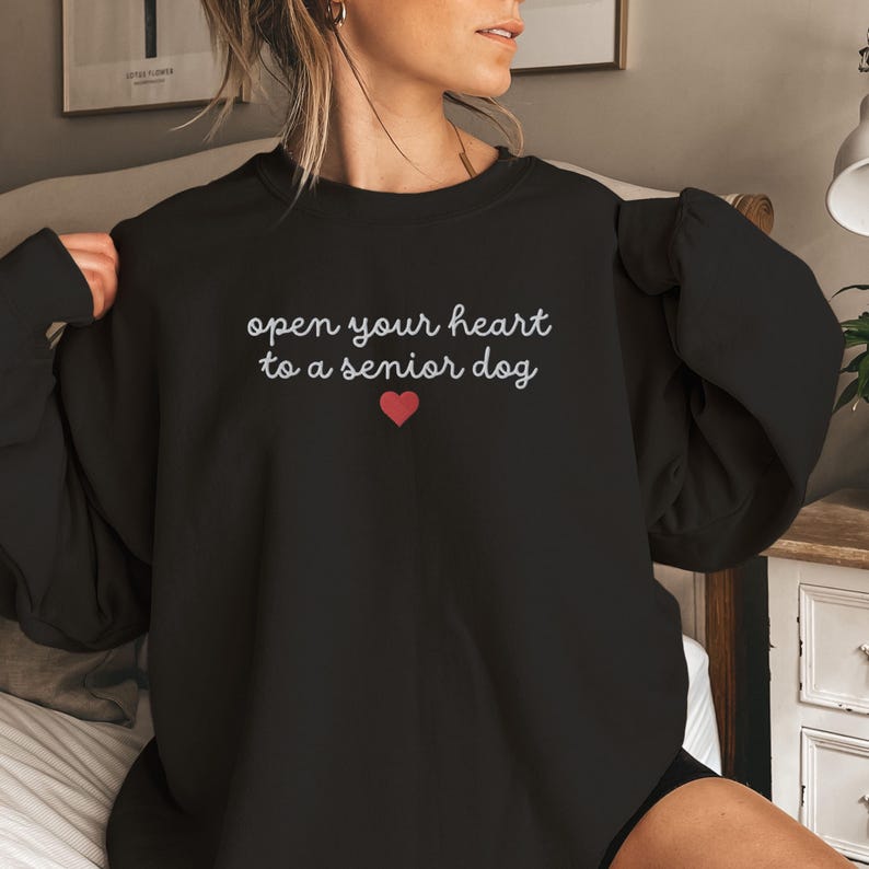 May include: Black sweatshirt with the text "open your heart to a senior dog" and a small red heart.