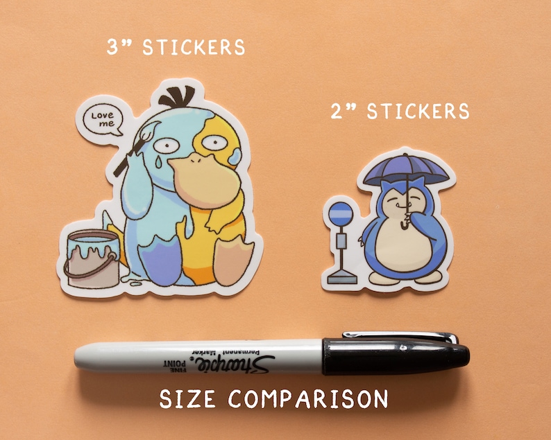 May include: Size comparison of two stickers. The larger sticker is 3 inches and features a blue and yellow cartoon character holding a paintbrush. The smaller sticker is 2 inches and features a blue cartoon character holding an umbrella. The text "Love me" is on the larger sticker.