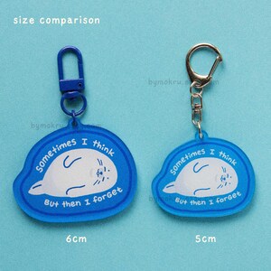 May include: Two blue acrylic keychains with a white seal illustration. The keychains have the text "sometimes I think But then I forget". One keychain is 6 cm and the other is 5 cm. Both have a metal clasp.