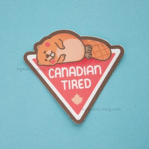 Puede incluir: Una pegatina con un castor de dibujos animados tumbado sobre un letrero triangular rojo y blanco. El letrero dice "CANADIAN TIRED" en texto blanco, con una hoja de arce. El castor es marrón y naranja.
