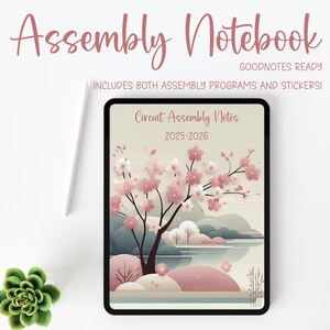 May include: A digital notebook with the title "Assembly Notebook" in a cursive font. The notebook displays a floral design with pink blossoms and the text "Circuit Assembly Notes 2025-2026." A white stylus and a small succulent are also visible.