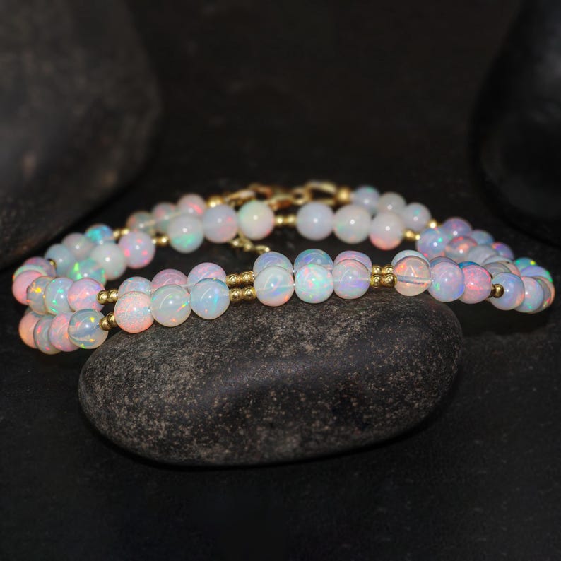 May include: A double strand necklace made of iridescent white opal beads separated by gold spacers.