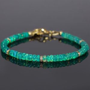 May include: A green opal gemstone bracelet with a gold clasp and small diamond accents.