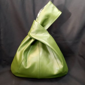 Japanese knot bag made of green leather and lined with forest print cotton