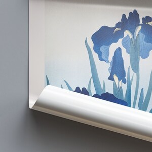 May include: A close-up of a white scroll with a blue and green floral design. The scroll is rolled up at the bottom and the top is partially unrolled, revealing the floral design.