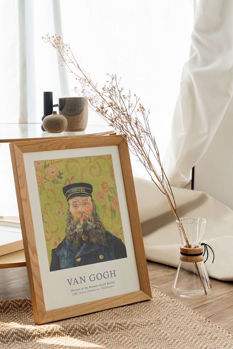 May include: A framed print of a painting by Vincent van Gogh titled "Portrait of the Postman Joseph Roulin". The painting depicts a man with a beard wearing a blue uniform and a black cap. The background is a green and yellow floral pattern.