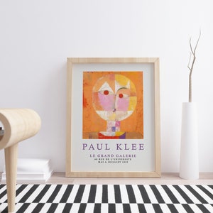 May include: A framed print of a painting by Paul Klee titled "Le Grand Galerie" with a geometric abstract design in shades of orange, pink, yellow, and white. The text "PAUL KLEE" and "LE GRAND GALERIE" is printed below the painting.