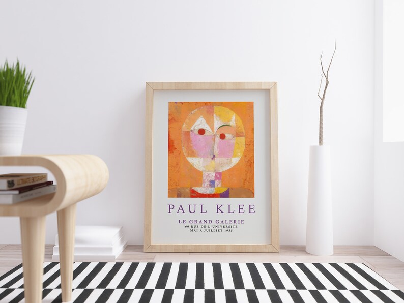 May include: A framed print of a painting by Paul Klee titled "Le Grand Galerie" with a geometric abstract design in shades of orange, pink, yellow, and white. The text "PAUL KLEE" and "LE GRAND GALERIE" is printed below the painting.
