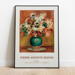 Op de afbeelding: Een ingelijste print van een schilderij van Pierre Auguste Renoir met de titel "Bloemen". Het schilderij toont een boeket kleurrijke bloemen in een groene vaas op een wit bord. De achtergrond is warm oranje en geel.