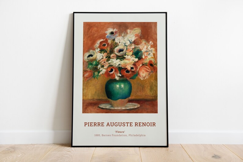 Op de afbeelding: Een ingelijste print van een schilderij van Pierre Auguste Renoir met de titel "Bloemen". Het schilderij toont een boeket kleurrijke bloemen in een groene vaas op een wit bord. De achtergrond is warm oranje en geel.
