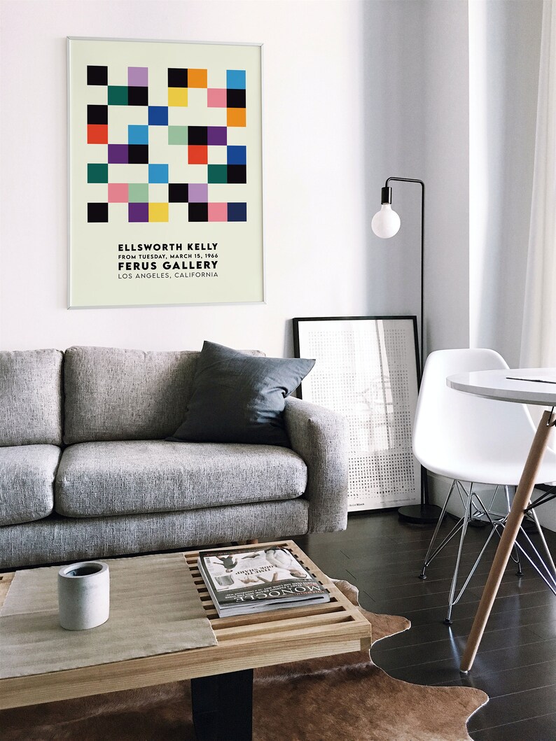 May include: A framed poster with a geometric design in various colors, including black, white, red, yellow, green, and blue. The poster is titled "ELLSWORTH KELLY" and includes the text "FROM TUESDAY, MARCH 15, 1966 FERUS GALLERY LOS ANGELES, CALIFORNIA".