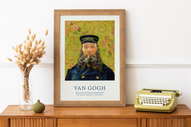 May include: A framed print of a painting by Vincent van Gogh titled "Portrait of the Postman Joseph Roulin." The painting depicts a man with a beard wearing a blue coat and a cap. The background is a green and yellow floral pattern.