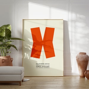 May include: A framed poster with a large orange X shape on a cream background. The poster text reads "Ellsworth Kelly, From Thursday, March 14, 1968, Ferus Gallery, Los Angeles, California."