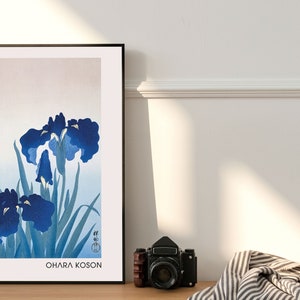 May include: A framed print of a Japanese-style painting of blue irises with green leaves. The print is titled "Ohara Koson" and features Japanese text in the lower left corner.