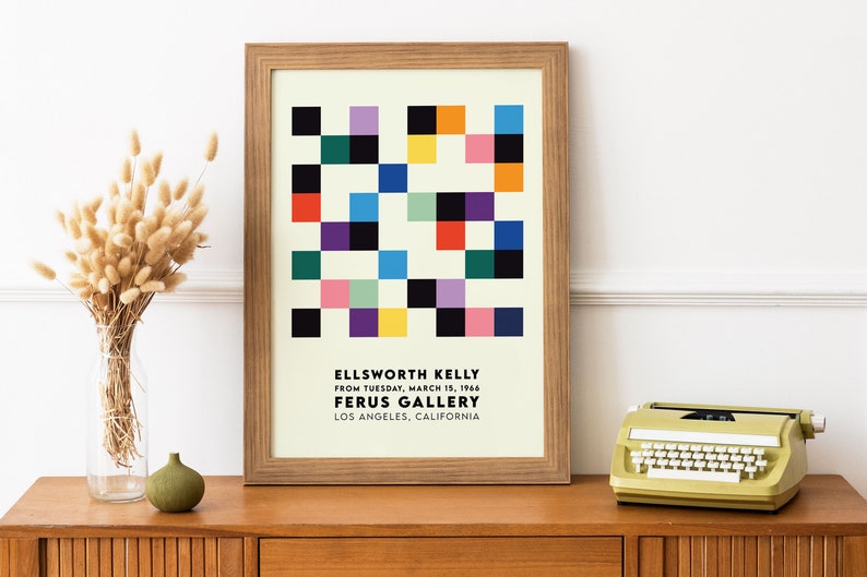 May include: A framed poster with a geometric design in shades of red, yellow, blue, green, black, and white. The poster is titled "ELLSWORTH KELLY" and includes the text "FROM TUESDAY, MARCH 15, 1966 FERUS GALLERY LOS ANGELES, CALIFORNIA".