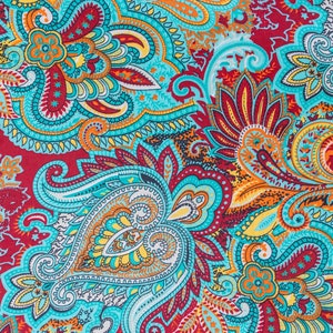 May include: A colorful paisley pattern fabric with a turquoise, red, orange, and yellow color scheme. The fabric has a repeating pattern of paisley shapes and floral designs.
