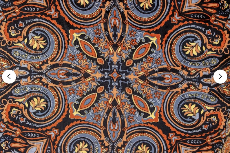 May include: A black background with a paisley pattern in shades of orange, blue, and yellow. The pattern is symmetrical and creates a mandala-like design.