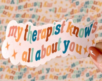 May include: A sticker with the text "my therapist knows all about you" in a retro font. The sticker has a light pink background with a repeating pattern of the same text and stars. The text is in various colors.