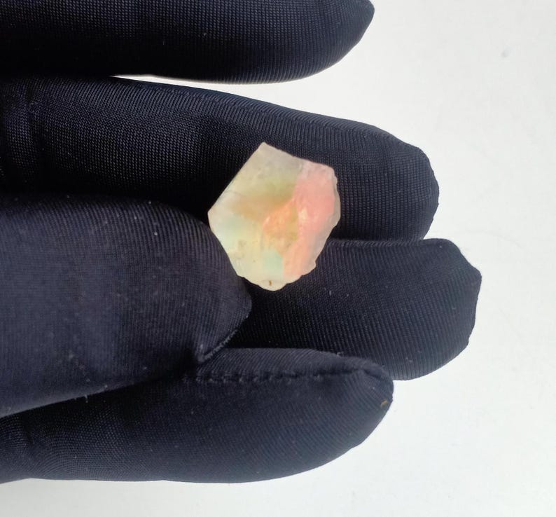 Puede incluir: Un peque&ntilde;o cristal transl&uacute;cido rosa y verde con una forma irregular y rugosa.