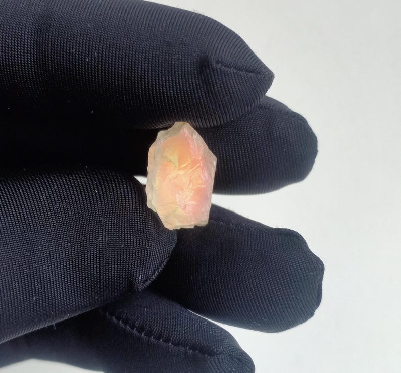 Puede incluir: Un peque&ntilde;o cristal transl&uacute;cido rosa y amarillo con una superficie rugosa y facetada.