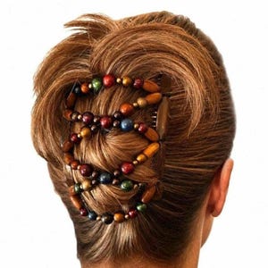 May include: A hair comb accessory featuring two dark brown plastic combs connected by elastic cords strung with multicolored wooden beads in shades of red, green, blue, and brown, secured in a brown hair bun.