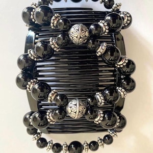 May include: Ornate black hair combs with black beads and silver accents. The combs feature large, glossy black beads and smaller silver-toned beads. The text "Ornate Black with Black Combs" is at the bottom of the image.