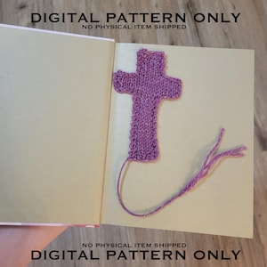 May include: A purple knitted cross bookmark with a long tassel. The bookmark is laying on a light brown surface. The text "DIGITAL PATTERN ONLY" is printed on the surface. "NO PHYSICAL ITEM SHIPPED" is also printed on the surface.