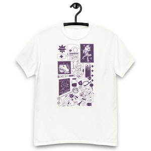 May include: White t-shirt with a purple graphic design. The design features various illustrations, including a radio, a robot, a shoe, and a tree. The shirt is hanging on a black hanger.