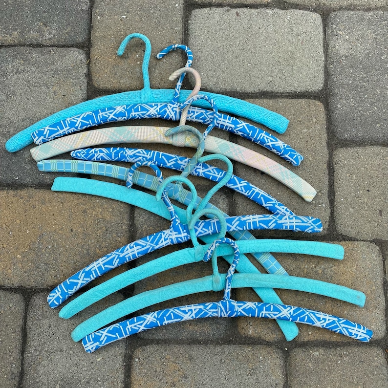 Puede incluir: Un conjunto de perchas de pl&aacute;stico azul y blanco con patrones. Las perchas son de diferentes tama&ntilde;os y tienen una variedad de patrones.