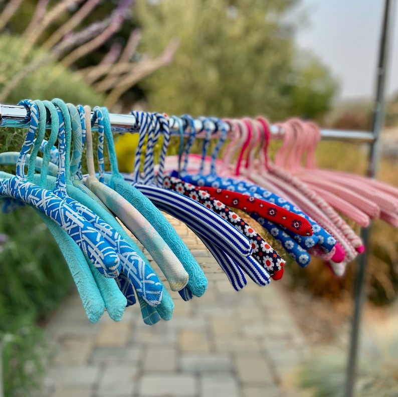 Puede incluir: Una colecci&oacute;n de perchas con patrones coloridos con dise&ntilde;os azules, blancos, rojos y rosas. Las perchas est&aacute;n hechas de un material suave y flexible y son perfectas para colgar ropa.