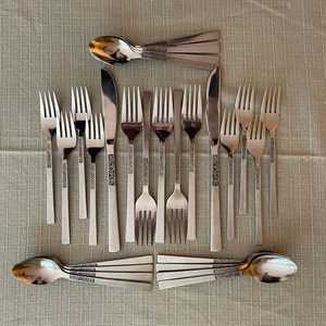 May include: A set of silver flatware with ornate handles. The set includes forks, knives, and spoons.