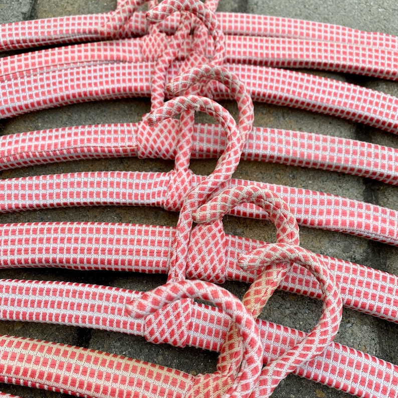 Puede incluir: Un conjunto de perchas de tela de cuadros vichy rosa y blanco. Las perchas est&aacute;n hechas de un material suave y flexible y est&aacute;n dise&ntilde;adas para proteger la ropa delicada.