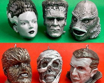 May include: Six different Halloween ornaments, each depicting a different monster. The ornaments are made of a hard, painted plastic and are designed to hang from a Christmas tree or other decorative object. The monsters include Frankenstein, the Creature from the Black Lagoon, a werewolf, a mummy, Dracula, and a zombie.