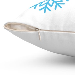 Pode incluir: Almofada branca com um desenho de floco de neve azul. A almofada tem um fecho de correr oculto. O floco de neve &eacute; de estilo simples, desenhado &agrave; m&atilde;o. A almofada &eacute; feita de um tecido texturizado.