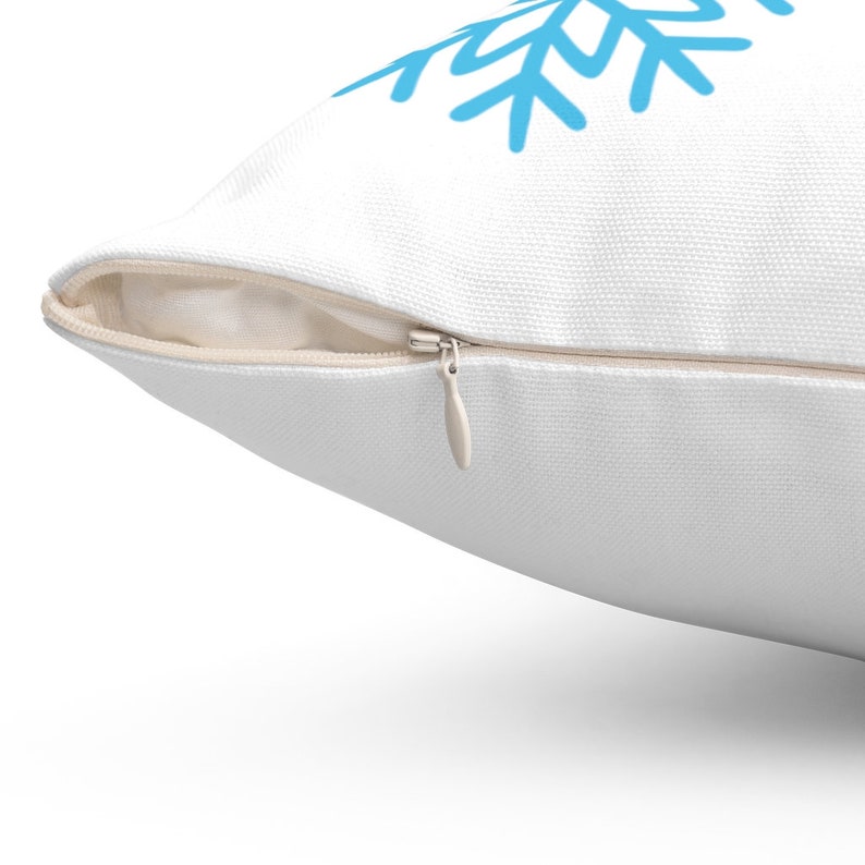 Pode incluir: Almofada branca com um desenho de floco de neve azul. A almofada tem um fecho de correr oculto. O floco de neve &eacute; de estilo simples, desenhado &agrave; m&atilde;o. A almofada &eacute; feita de um tecido texturizado.