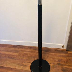 Peut inclure: Un lampadaire en m&eacute;tal noir avec une base chrom&eacute;e et un abat-jour rond noir.