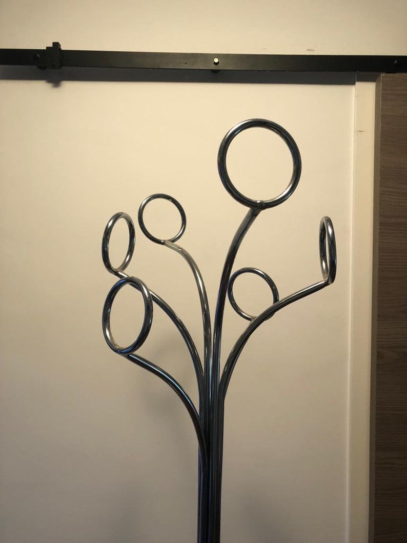 Peut inclure: Un porte-manteau en chrome avec un design en forme d'arbre. Le porte-manteau a six crochets en forme de cercles.