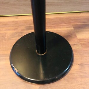 Peut inclure: Un porte-manteau en m&eacute;tal noir avec une base ronde. La base pr&eacute;sente une l&eacute;g&egrave;re &eacute;br&eacute;chure sur le bord.