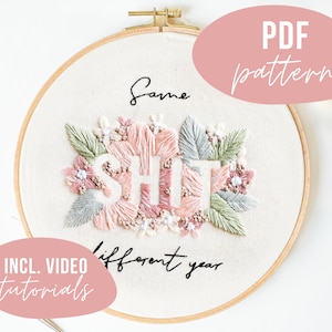 Könnte beinhalten: Stickrahmen-Kunst mit der Aufschrift "Same shit different year", umgeben von rosa und grüner Blumenstickerei. Der Rahmen befindet sich auf einem weißen Hintergrund mit einem rosa Kreis, auf dem "PDF pattern" steht, und einem weiteren rosa Kreis, auf dem "INCL. VIDEO tutorials" steht.